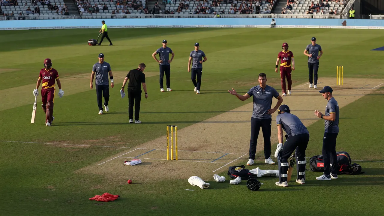 Fielders gathered in a ring on the edge of the circle as a batter and non-striker reset between deliveries in a day-night match
